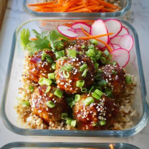 Maple-Sriracha cocktail meatballs served over rice with garnishes.
