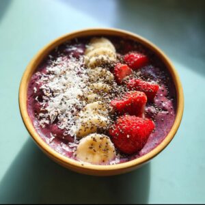 Colorful smoothie bowl topped with banana, strawberries, and chia seeds.